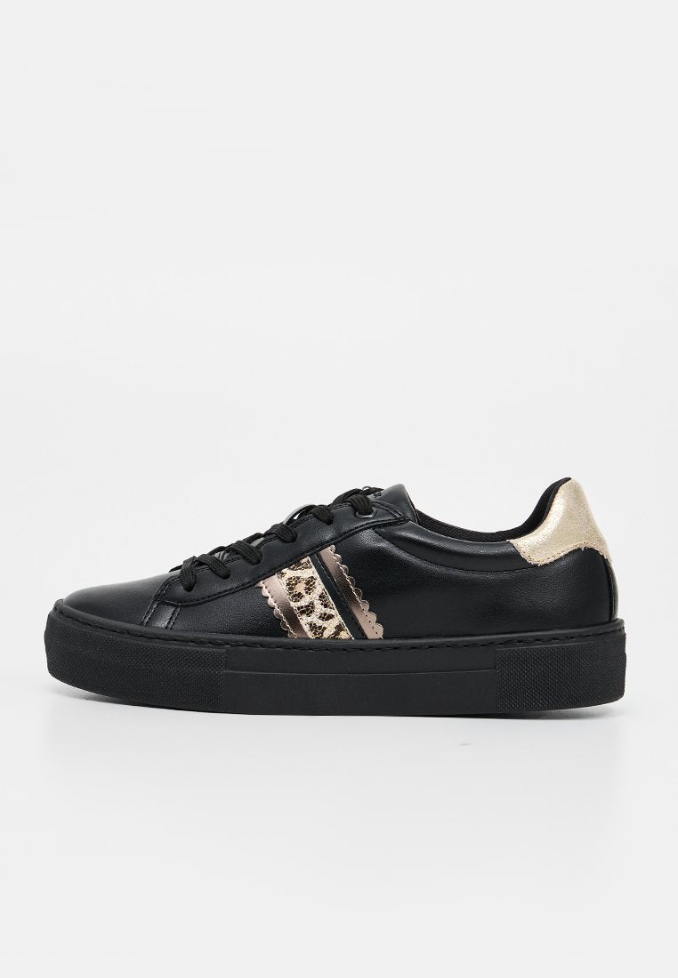 Schwarzer Sneaker mit niedrigem Schnitt, dicker Sohle, schwarzen Schnürsenkeln, metallisch goldener Ferse und Leopardenmuster mit gezacktem Rand am seitlichen Streifen.