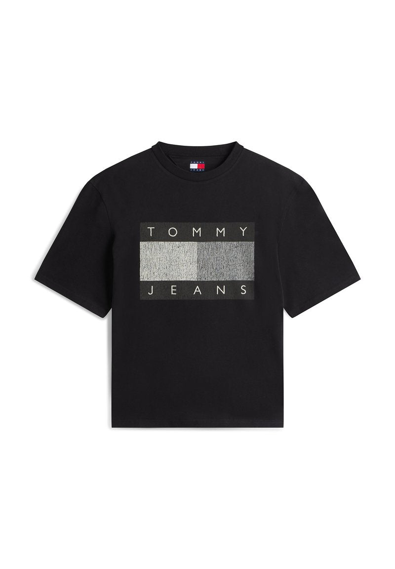 Schwarzes Baumwoll-T-Shirt mit einem rechteckigen Motiv, auf dem "TOMMY" und "JEANS" in Weiß vor einem strukturierten grauen Hintergrund zu sehen sind. Kurze Ärmel.