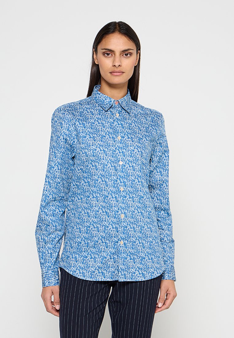 Blaues Hemd mit Knopfleiste und floralem Muster, mit spitzem Kragen und langen Ärmeln, gefertigt aus einem glatten Stoff.