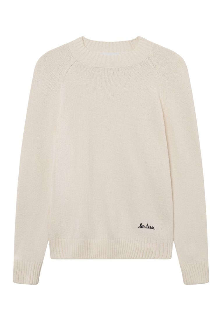 Cremfarbener, gestrickter Pullover mit ribbeligem Rundhalsausschnitt, Raglanärmeln und einem kleinen schwarzen Logo, das an der unteren Seite gestickt ist.