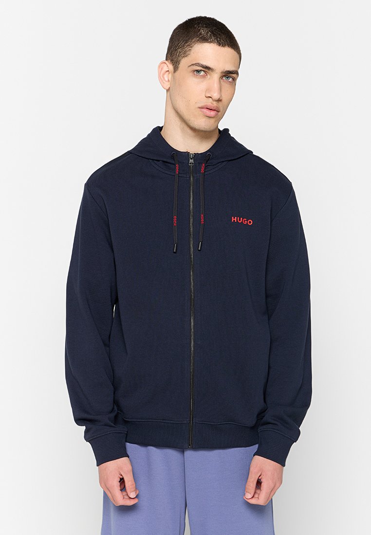 Marinefarbener Reißverschluss-Hoodie aus weichem Stoff, mit einer Kapuze mit Kordelzug und einem roten "HUGO"-Logo auf der Brust. Ribbed Bündchen und Saum.