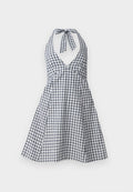 Halterkleid in Marineblau und Weiß im Gingham-Muster mit tiefem V-Ausschnitt und Bindeband im Rücken. Ausgestellter Rock mit tailliertem Oberteil und Faltendetails.