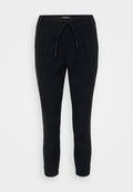 Schwarze Cordhose mit Kordelzugbund, schmal zulaufenden Beinen und strukturierter Oberfläche. Geeignet für legere Anlässe.