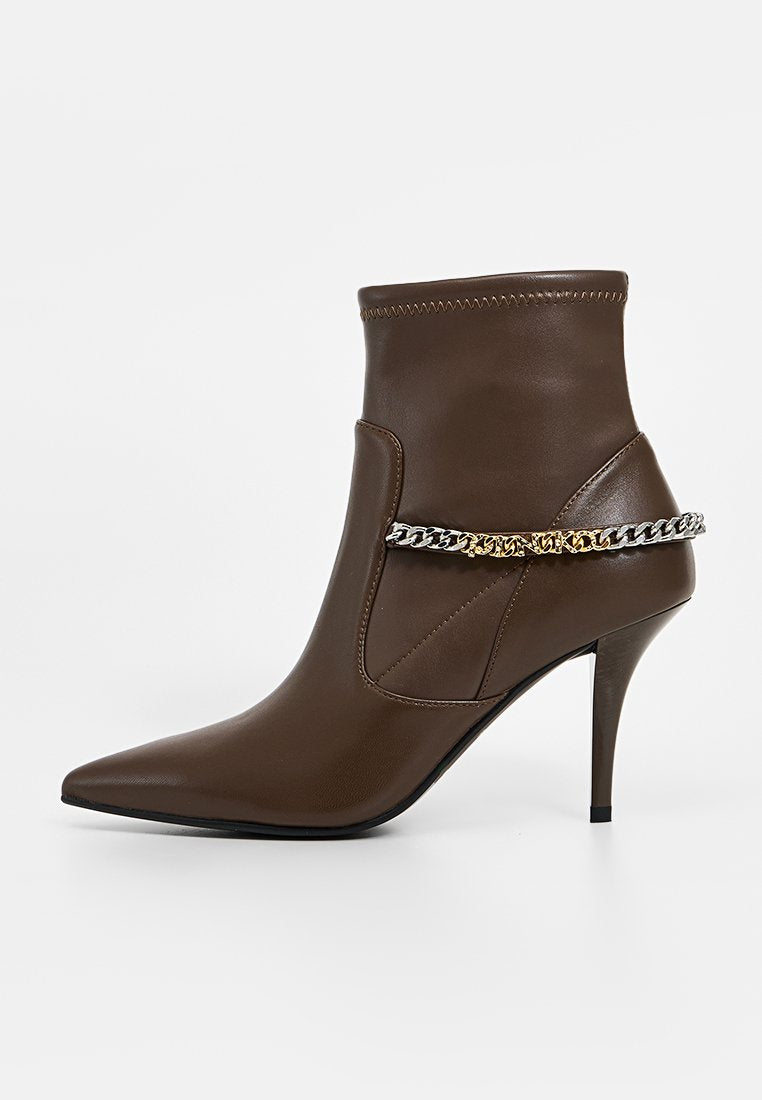 Braune Leder-Ankle Boots mit spitzem Zehenbereich und Stiletto-Absatz. Mit einem silbernen und goldenen Kettenakzent über dem Obermaterial. Sanfte Textur.