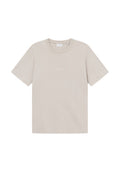 Beige Baumwoll-T-Shirt mit kurzen Ärmeln, rundem Halsausschnitt und dezentem 'LES DEUX'-Text in Weiß auf der Vorderseite. Glatte Textur.
