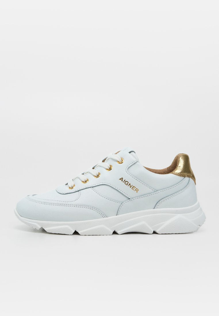 Weißer Sneaker mit goldener metallischer Fersenlasche, goldenen Ösen und „AIGNER“-Logo an der Seite, mit dicker weißer strukturierter Sohle.