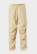 Helle beige Nylon-Cargohosen mit verstellbaren Drawstrings an der Taille und Reißverschlusstaschen, gestaltet mit gerafften, geschichteten Stoffdetails.