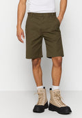 Olivgrüne Shorts aus Baumwollmix mit einer regulären Passform, Gürtelschlaufen und seitlichen Taschen. Kombiniert mit beigen Kampfstiefeln.