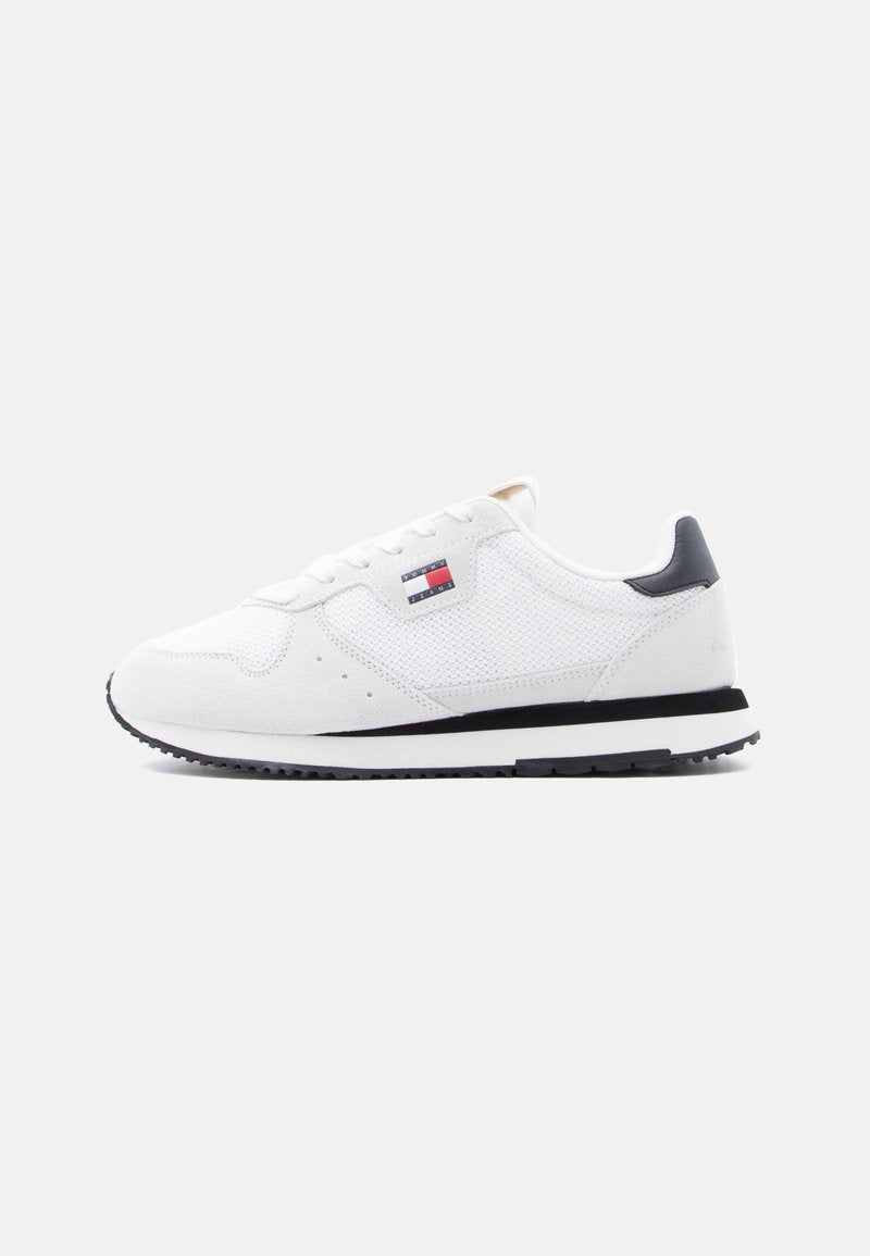 Weißer Sneaker in Low-Top-Form mit Mesh- und Wildleder-Einsätzen, schwarzer Fersenlasche, schwarz-weißer Sohle und Tommy Jeans Logo an der Seite.