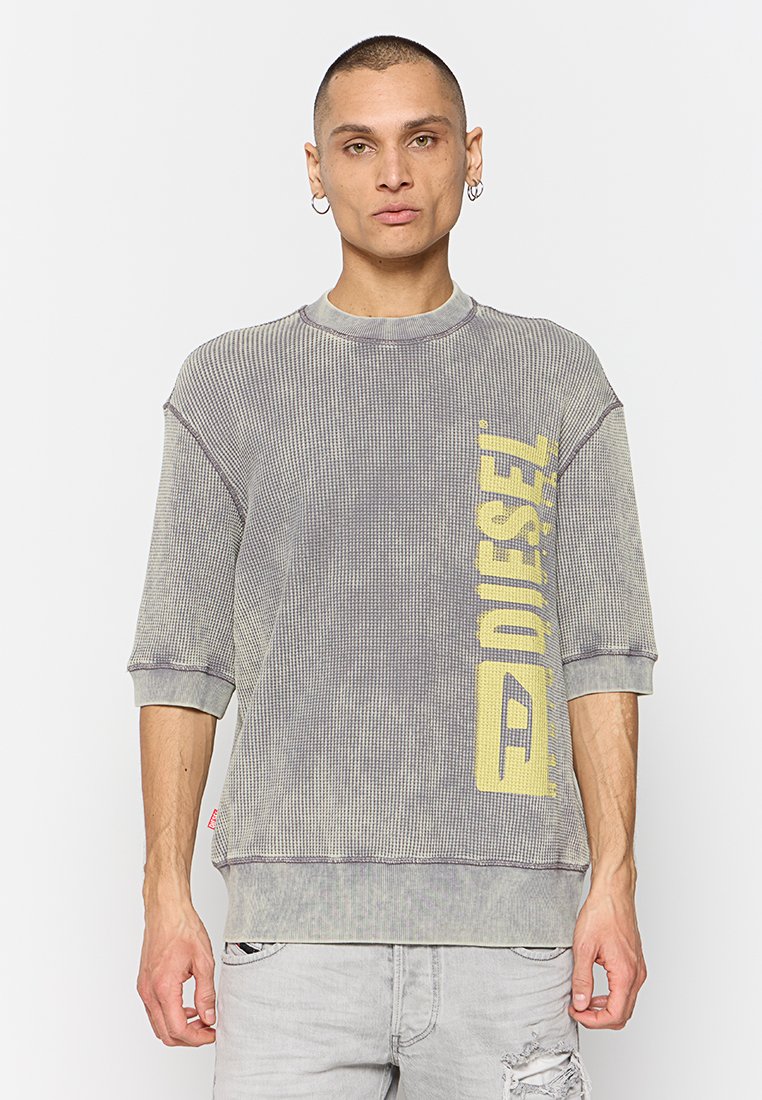 Grauer Ripp-Pullover mit gelbem "DIESEL"-Text, kurzen Ärmeln, Rundhalsausschnitt und sichtbaren Nähten. Baumwoll-Mix-Stoff mit Struktur.