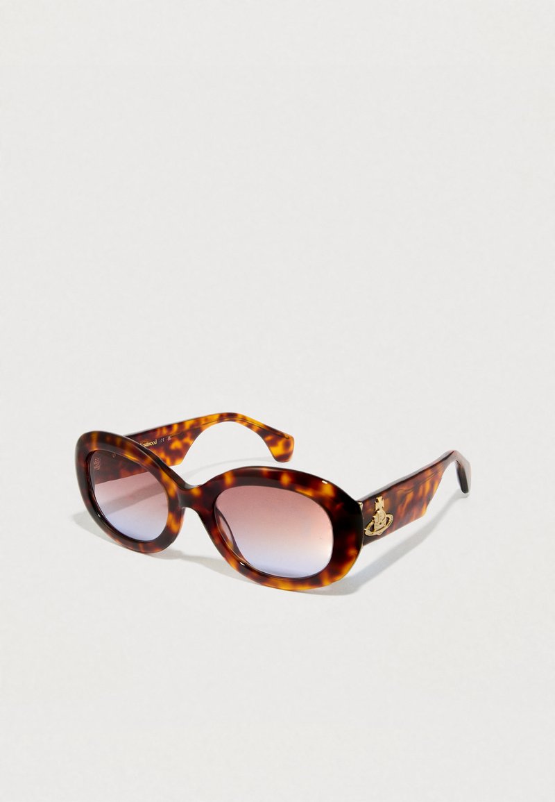 Sonnenbrille aus Schildpatt mit ovalen Rahmen, verlaufsfähigen Gläsern und goldenen Hardware-Details an den Schläfen. Glatte, glänzende Kunststoffoberfläche.