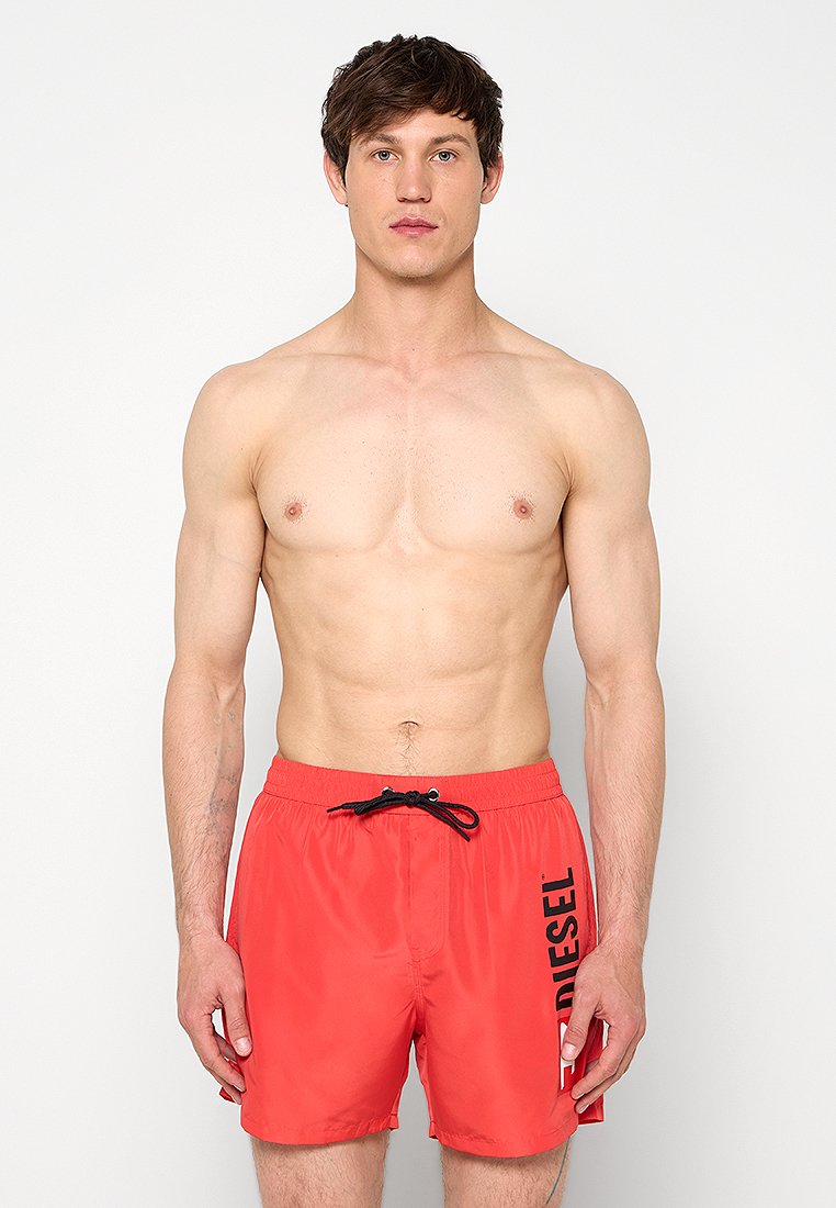 Rote Badeshorts aus leichtem, schnell trocknendem Stoff. Sie verfügen über einen elastischen Bund mit Kordelzug und einen seitlichen Logodruck.
