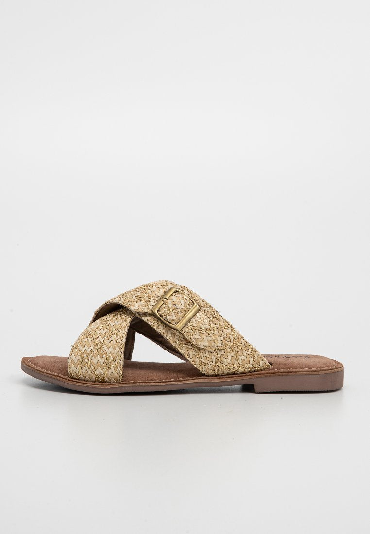 Geflochtene Strohsandale in Beige, mit einem Überkreuzriemen-Design und einem goldfarbenen Schnallen-Detail sowie einer flachen, braunen synthetischen Sohle.