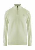Hellgrüner Pullover aus weichem Stoff, mit einem halben Reißverschluss am Kragen, gerippten Bündchen und einem kleinen Etikett mit Logo auf der Brust.