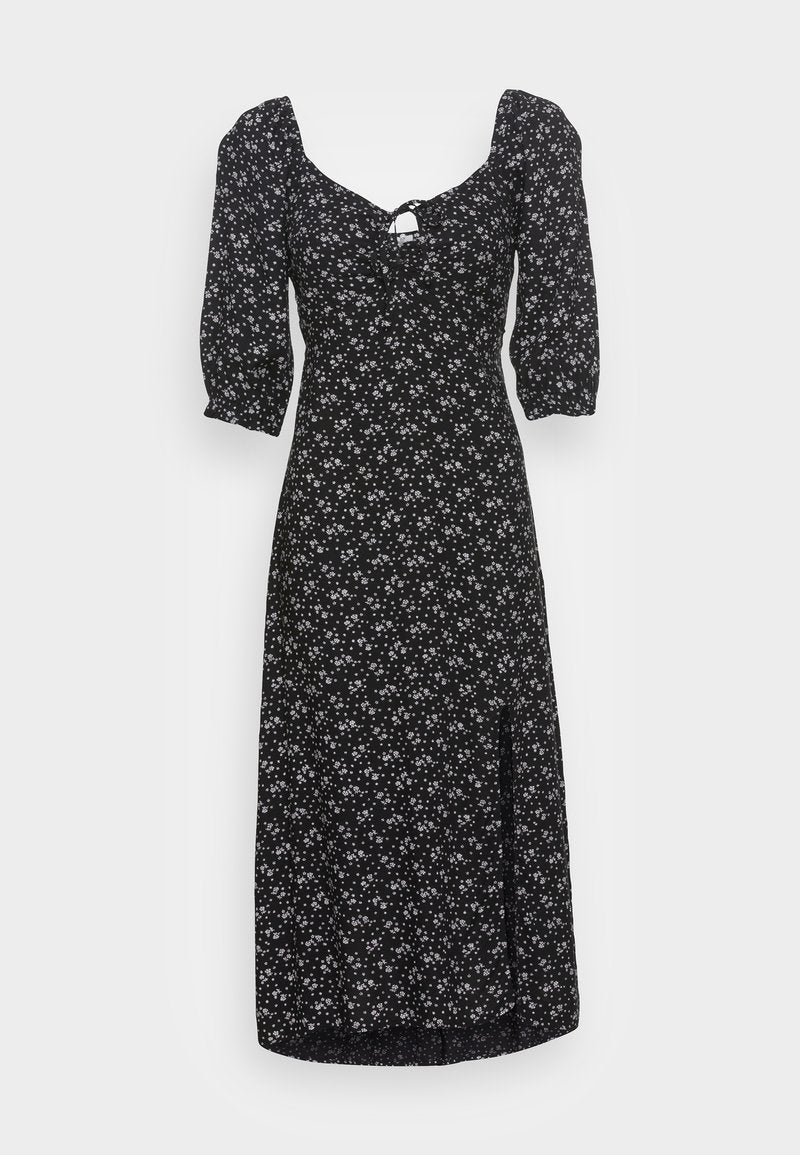 Schwarzes, florales Midikleid mit Puffärmeln, tailliertem Oberteil und einem Schlüssellochdetail. Enthält weiße Blumenmuster auf der gesamten Fläche. Glatte Stoffoberfläche.
