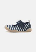 Marineblau-weiß gestreifter Stoffschuh mit Klettverschluss, runder Zehenpartie und leicht beiger Gummisohle. Strukturierter Oberstoff mit Nahtdetails.