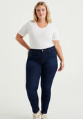 Dunkelblaue Jeans mit hoher Taille, dehnbarem Denim-Stoff, subtilen Nähten und einem weißen V-Ausschnitt-T-Shirt, getragen mit weißen Turnschuhen.