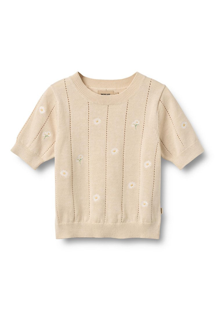 Hellbeiger Kurzarmpullover mit vertikaler Rippenstruktur und bestickten weißen Blumen. Weiche Textur, runder Ausschnitt und taillierter Saum.