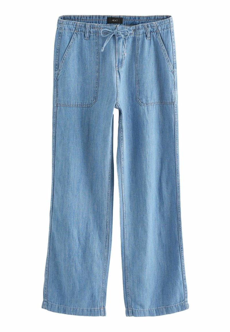 Hellblaue Jeanshose mit lässiger Passform, elastischem Bund, Kordelzugverschluss und zwei vorderen Taschen auf einer flachen Oberfläche.