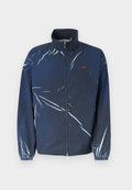 Dunkelblaue Jacke mit Reißverschluss, weißen abstrakten Streifen, elastischen Bündchen und einem kleinen roten Logo auf der linken Brust.