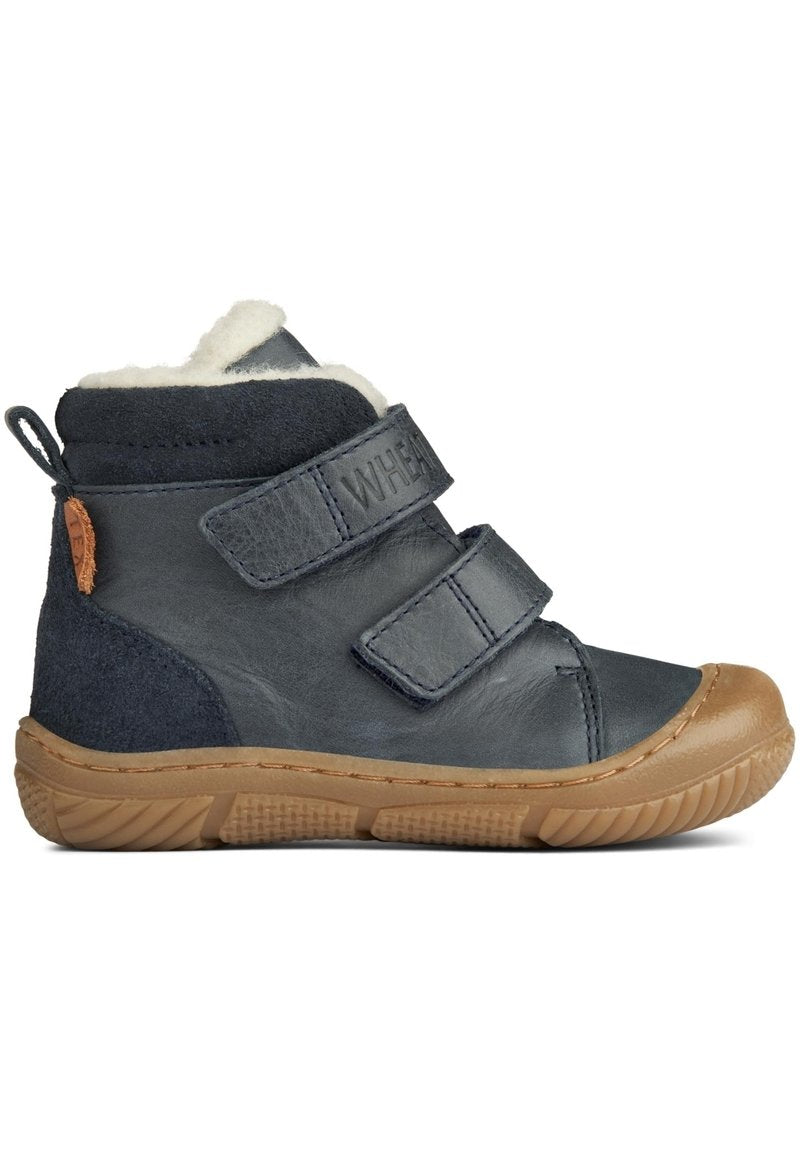 Navy Leder- und Wildleder Stiefelette mit zwei Klettverschlüssen. Cremefarbene Innenausstattung, Gummisohle mit strukturiertem Grip und einem tanfarbenen Akzent an der Ferse.
