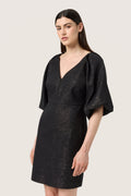 Schwarzes Kleid mit V-Ausschnitt, Puffärmeln und taillierter Silhouette. Der Stoff hat einen strukturierten Glanz mit dezenten metallischen Akzenten.