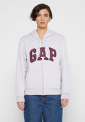Grauer Kapuzenpullover mit Reißverschluss, großer bordeauxroter "GAP"-Logo, einer Fronttasche und einer Kapuze mit Kordelzug. Der Stoff wirkt weich und strukturiert.