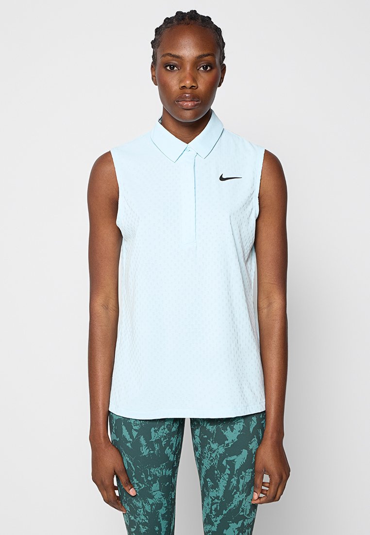 Helles blaues ärmelloses Polohemd mit strukturiertem Muster, Knopfleiste und schwarzem Nike-Logo auf der linken Brust, kombiniert mit legging in grünem Muster.