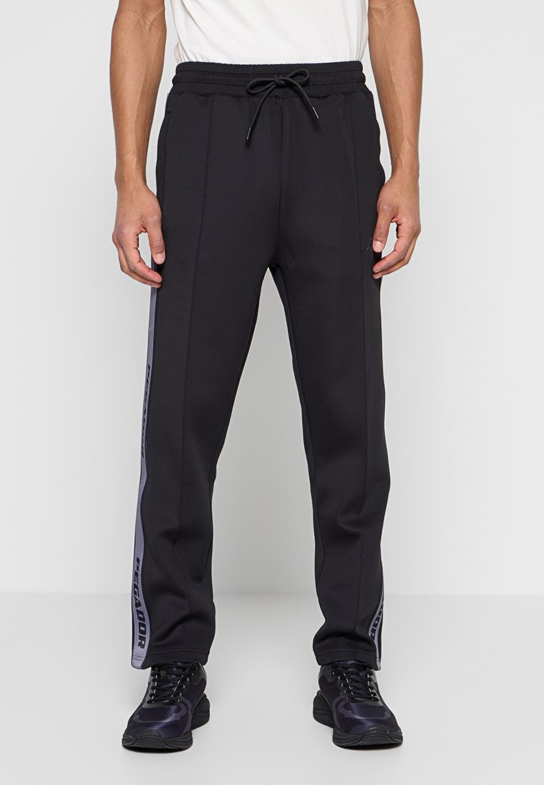 Schwarze Jogginghose mit seitlichen Streifen in Lila, Kordelzugbund und schmal zulaufender Passform, gefertigt aus weichem, strukturiertem Material.