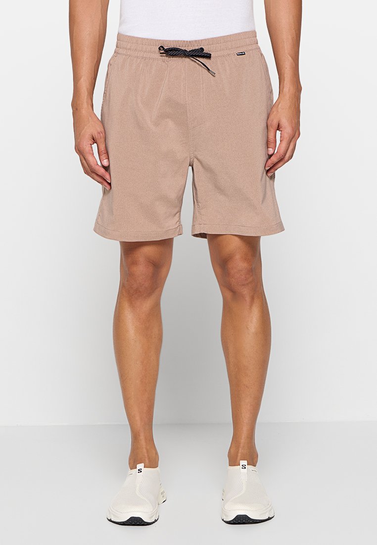 Braune Shorts, bis zur Mitte des Oberschenkels, mit elastischem Bund und schwarzem Kordelzug. Hergestellt aus weichem Stoff, mit flacher Vorderseite und Seitennähten.