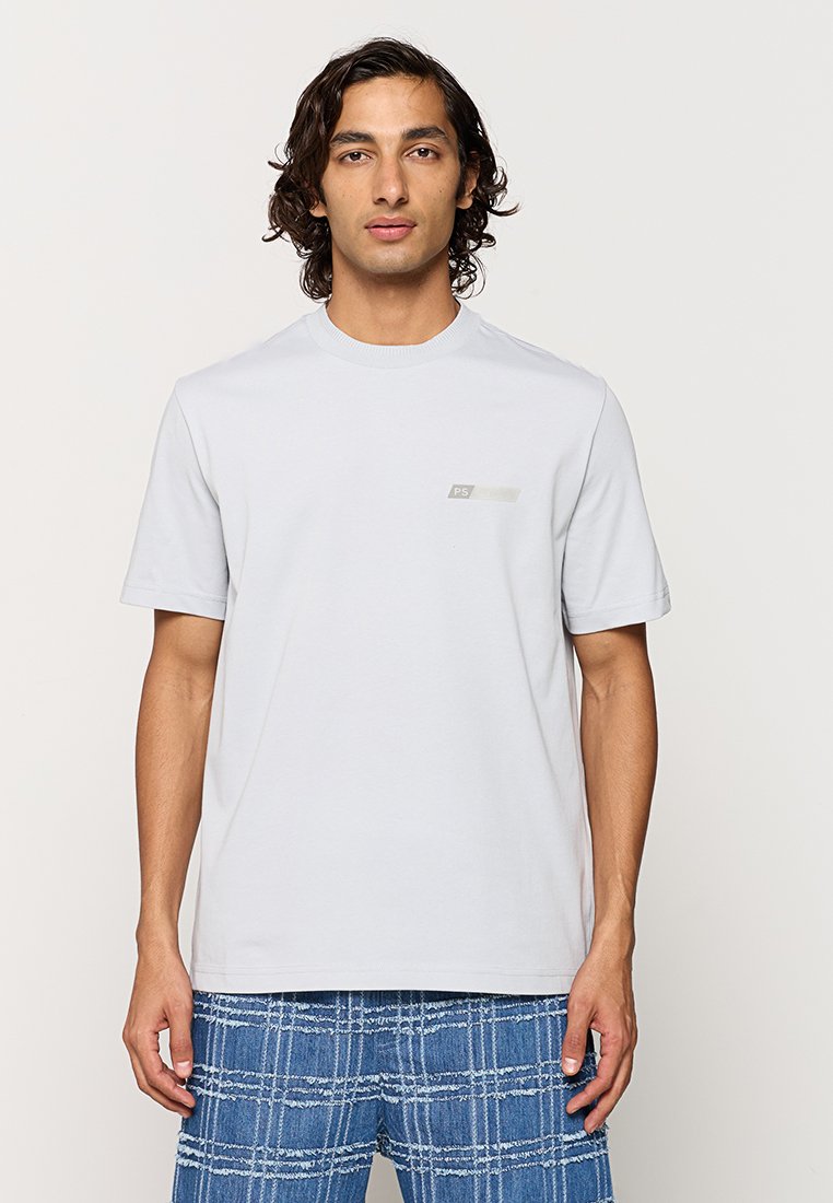 Hellgraues Kurzarm-T-Shirt mit rundem Halsausschnitt und kleinem grafischem Logo auf der Brust. Glatte Baumwolltextur.