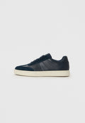 Marineblaue Sneakers mit einer Kombination aus glatten und strukturierten Materialien, einer weißen Sohle, flachen Schnürsenkeln und dezenten Seitenpaneelen.