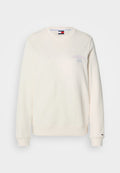 Cremfarbener Sweatshirt mit Rundhalsausschnitt, langen Ärmeln und einem kleinen lila Logo auf der Brust. Weicher, strukturiertes Material mit gerippten Bündchen.