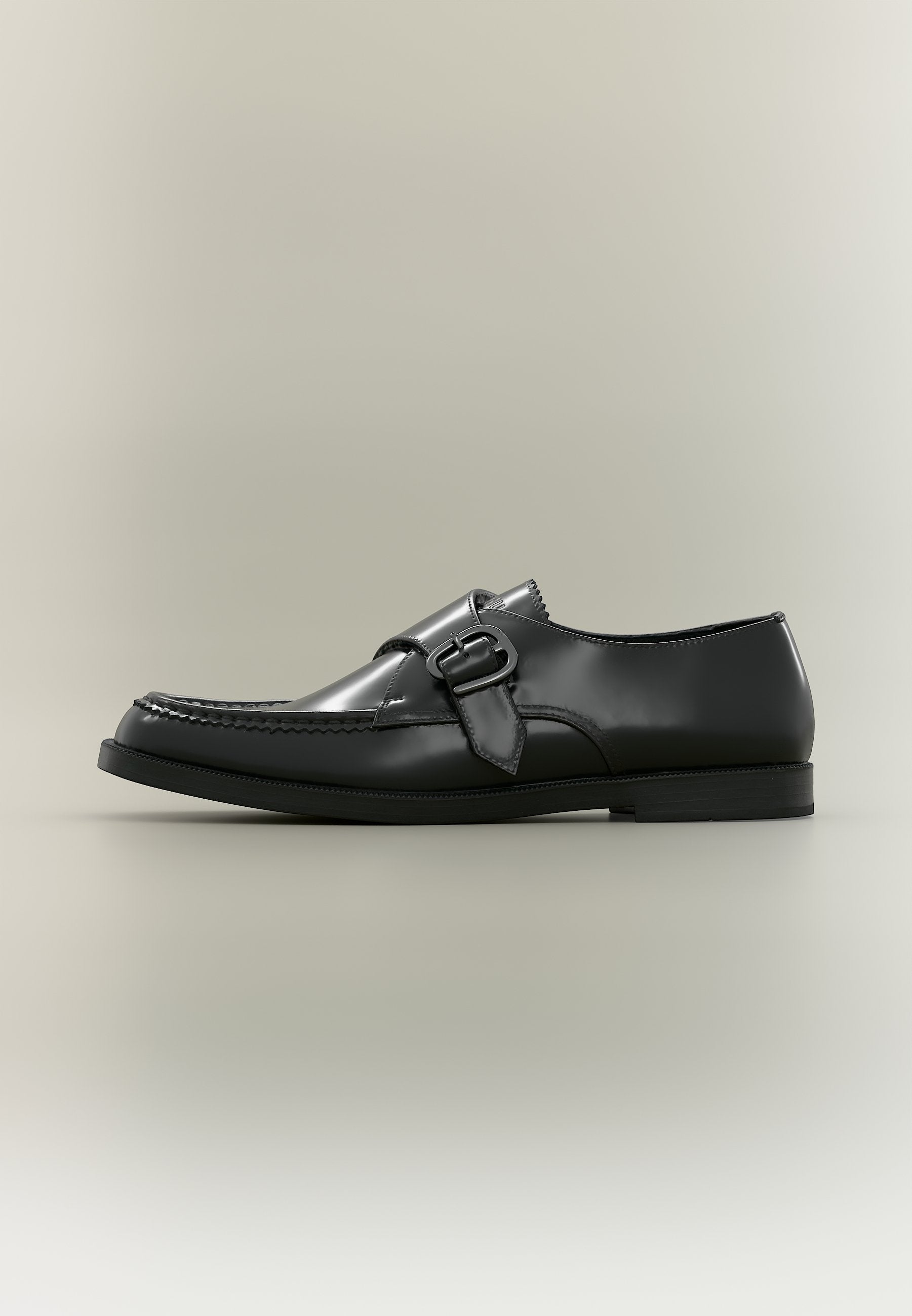 Schwarzer Lederschuh mit seitlicher Schnalle und Nahtdetail, im Profil vor neutralem Hintergrund gezeigt.