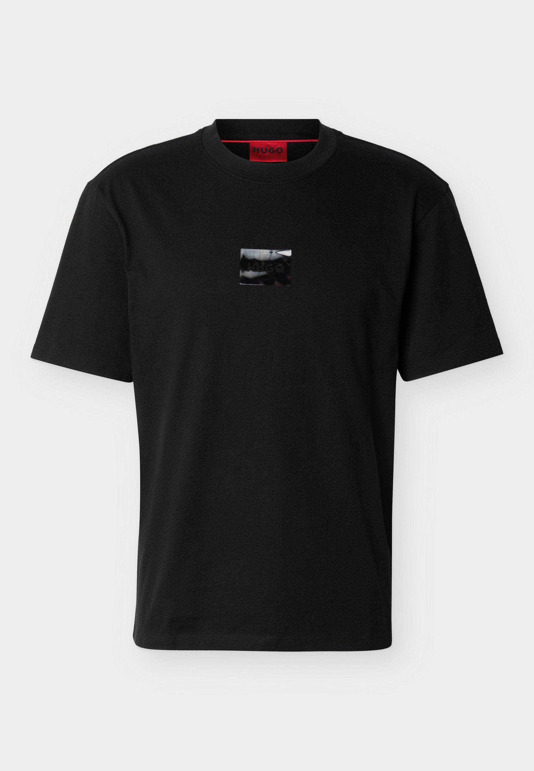 Schwarzes T-Shirt mit kurzen Ärmeln, auf der Brust mittig mit einem kleinen glänzenden schwarzen Quadrat-Logo-Patch und einem roten inneren Kragenetikett.