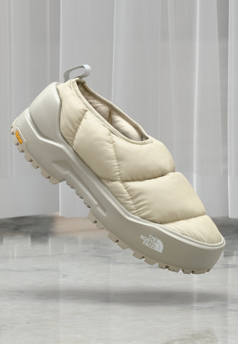 Beige gepolsterter Slipper mit strukturiertem Obermaterial, dickem weißen Zwischensohle und robustem Gummilaufsohle. Verfügt über eine Zuglasche hinten und ein Logo-Detail.