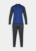 Männlicher Sportanzug mit blauer Jacke mit Reißverschluss und schwarzen Ärmeln sowie Hose, die pinkfarbene Nike-Logos auf der Brust und dem Oberschenkel trägt.