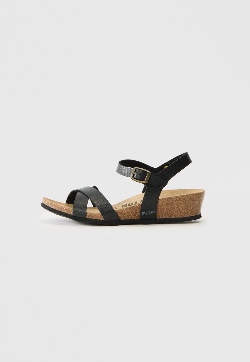Schwarze Kork-Wedge-Sandale mit Kreuzriemen-Design, verstellbarem Knöchelriemen, strukturiertem Material und niedrigem Absatz.