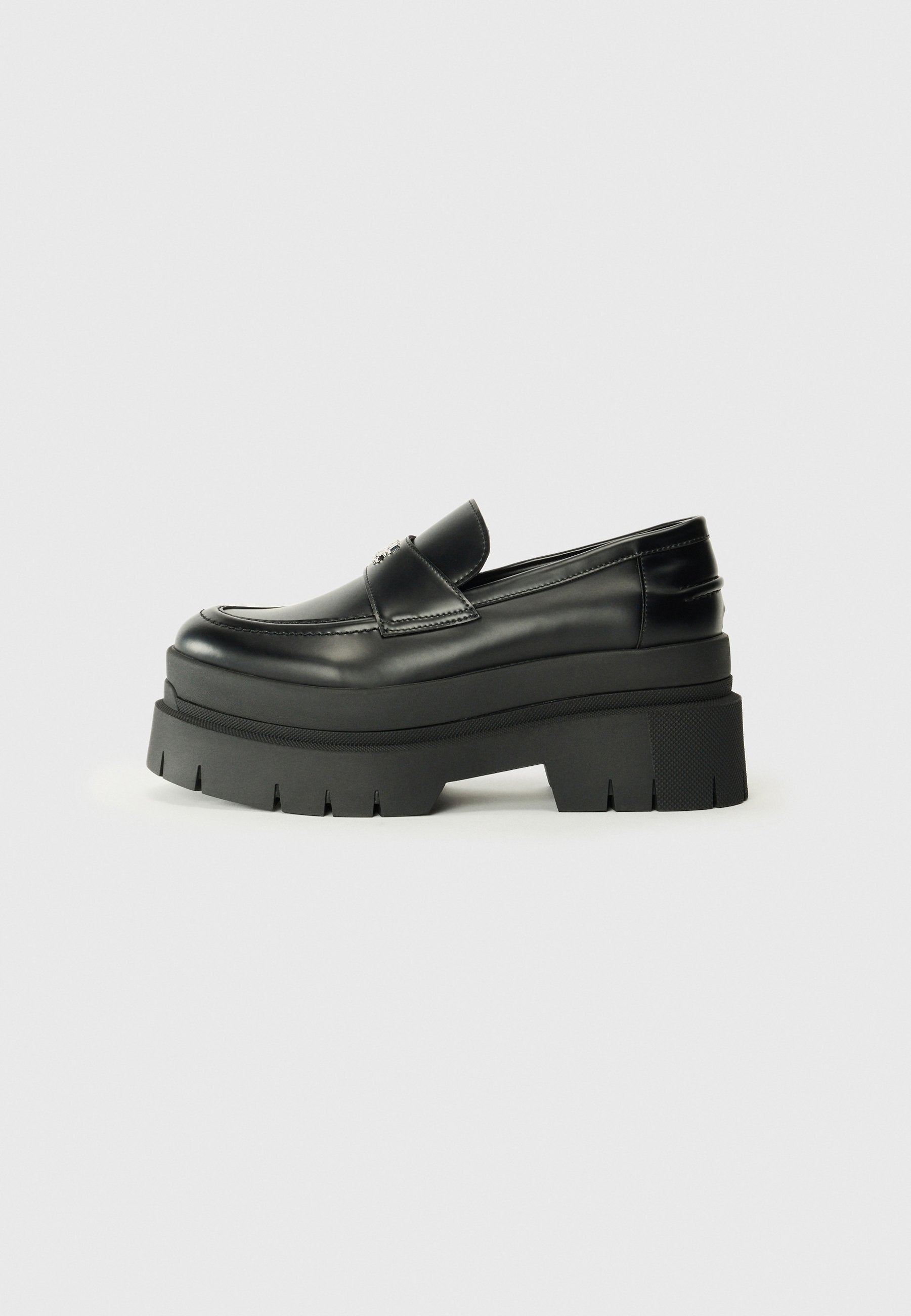 Schwarze Lederloafer mit einer klobigen Plateausohle. Abgerundete Spitze, Nahtdetail auf der Vorderseite und dezente Nähte. Flache, strukturierte Außensohle.