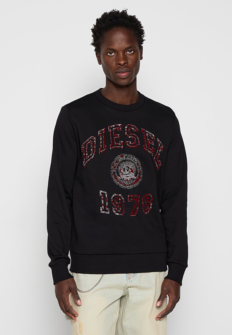Schwarzer Sweatshirt aus Baumwolle mit geripptem Rundhalsausschnitt. Auf der Vorderseite befindet sich ein großes rotes "DIESEL 1978"-Logo, das Material hat eine strukturierte Oberfläche mit dezenten Mustern.