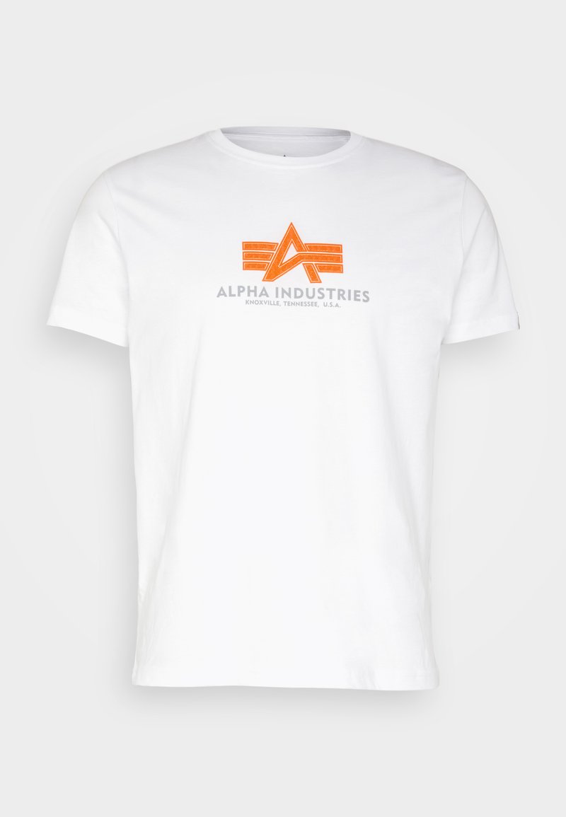 Weißes Baumwoll-T-Shirt mit einem grafischen Druck in Orange und Grau, das den Text "ALPHA INDUSTRIES" unter einem stilisierten Logo zeigt.