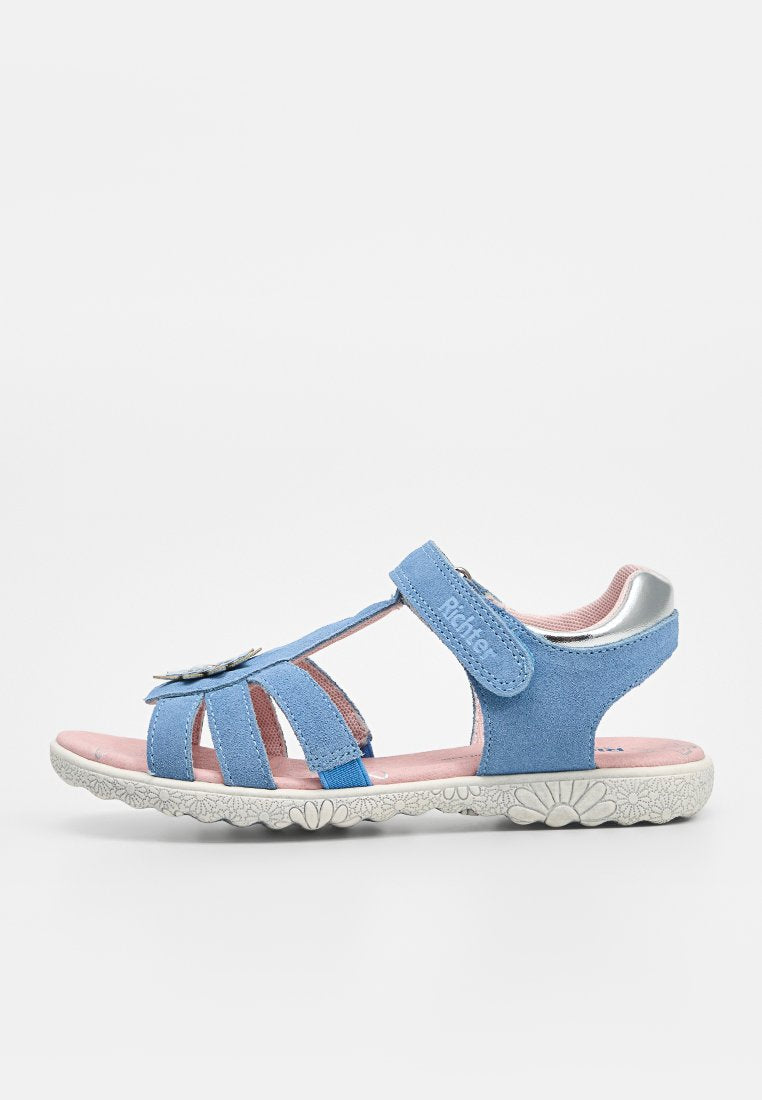Offene blaue Kindersandale aus Veloursleder mit verstellbarem Klettverschluss, pink gepolsterter Innensohle, silbernem Fersenakzent und weißer Sohle mit Blumenmuster.