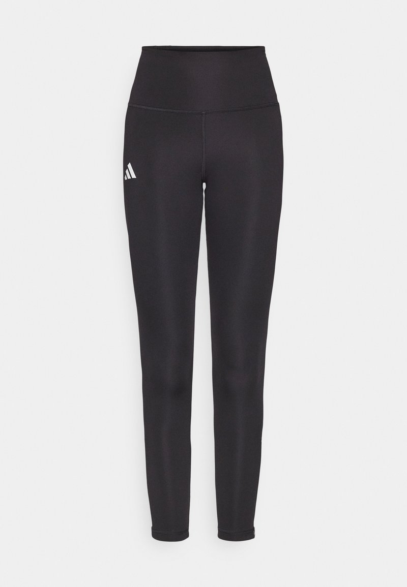 Schwarze hochgeschnittene Leggings aus dehnbarem Stoff. Mit einem weißen Logo auf der linken Seite und einem eleganten, nahtlosen Design. Glatte Textur.