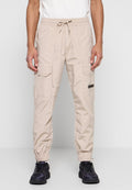 Beige Cargo-Hosen mit elastischem Bund, Kordelzug, Seitentaschen und elastischen Bündchen. Hergestellt aus leichtem, glattem Stoff.
