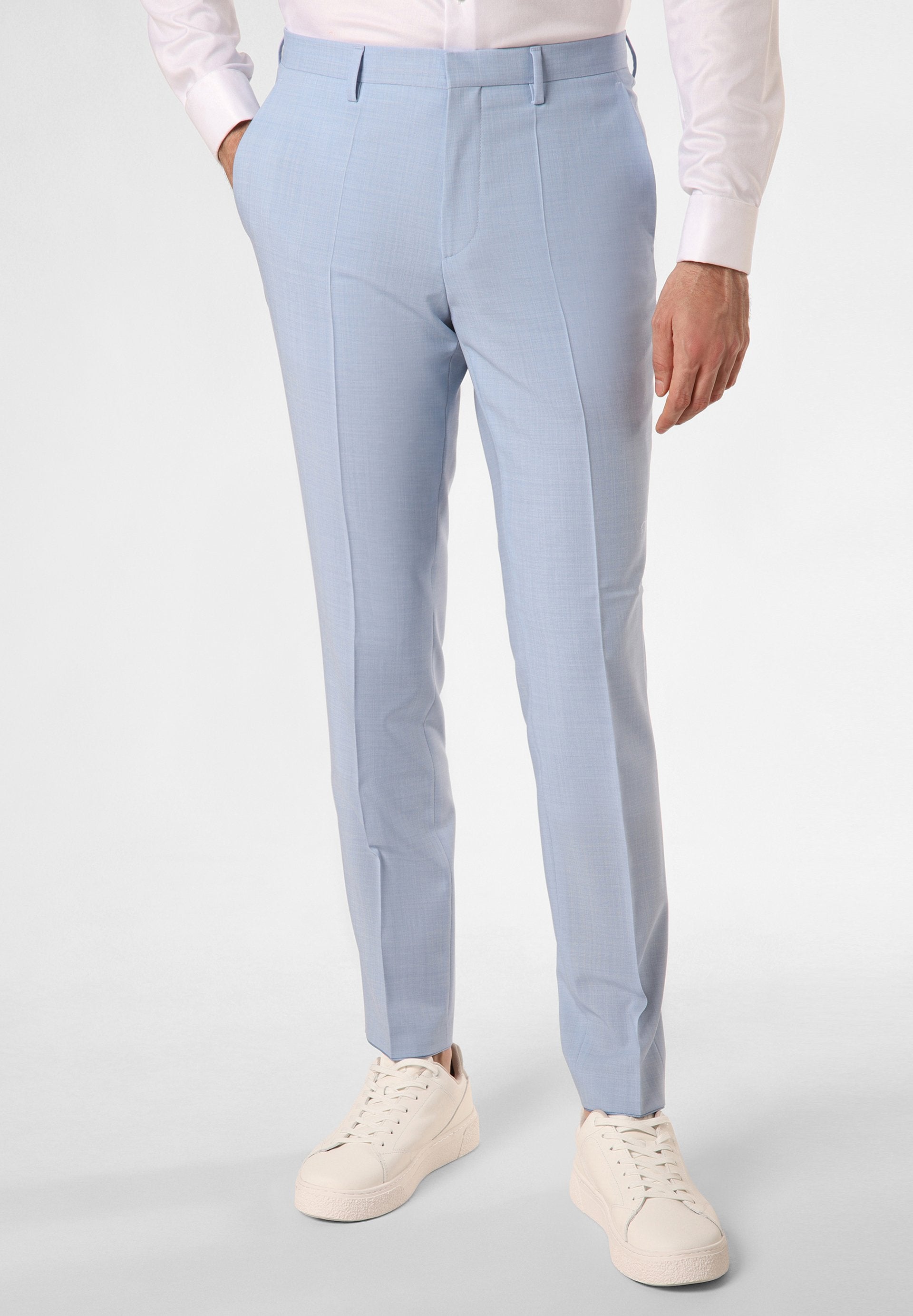 Himmelblaue, maßgeschneiderte Hose aus strukturiertem Stoff, mit schlanker Passform und Seitentaschen, kombiniert mit weißen Sneakers.