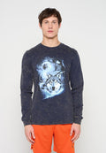 Junger Mann trägt ein verblasstes schwarzes Langarmshirt mit einer blauen Wolfsgrafik und leuchtend orangefarbene Sportshorts.