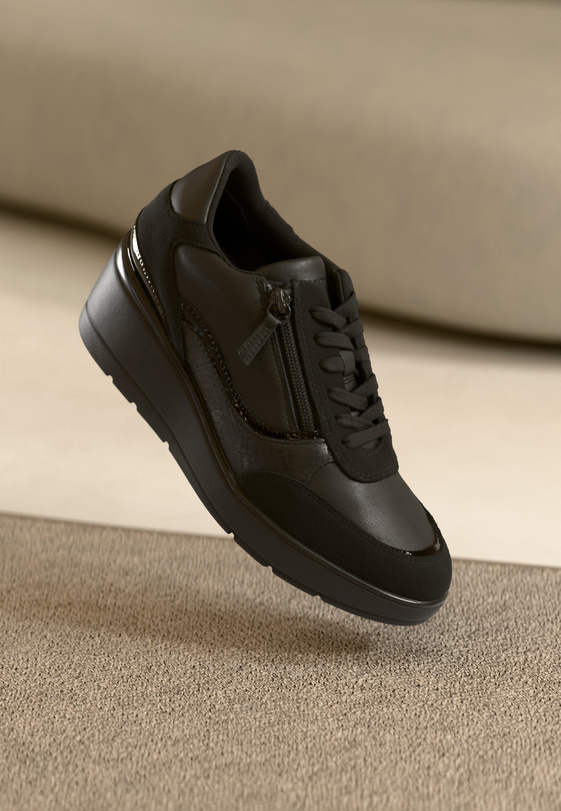 Schwarze Sneakers aus strukturiertem Leder und Mesh, mit einem seitlichen Reißverschluss, Schnürung vorne und einer leicht erhöhten Gummisohle.