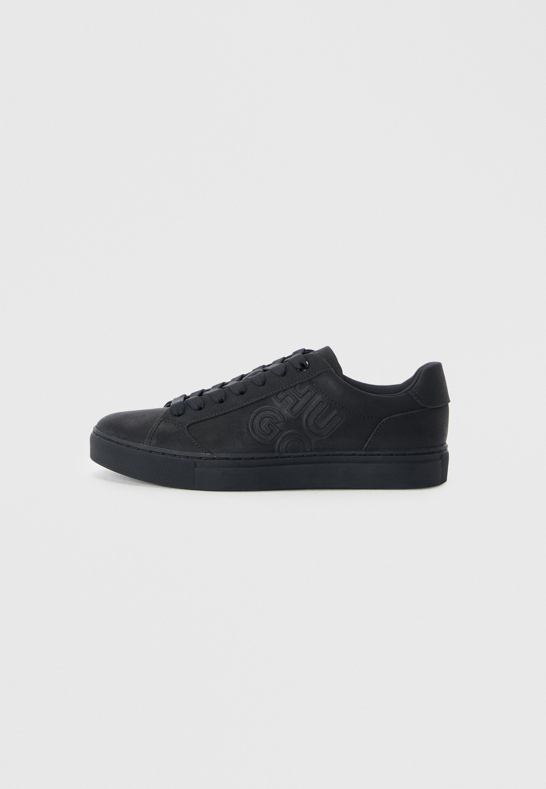 Schwarze Sneakers mit einer glatten lederähnlichen Oberfläche, rundem Zehenbereich, flacher Gummisohle und erhabenem Logo-Detail an der Seite. Schnürdesign.