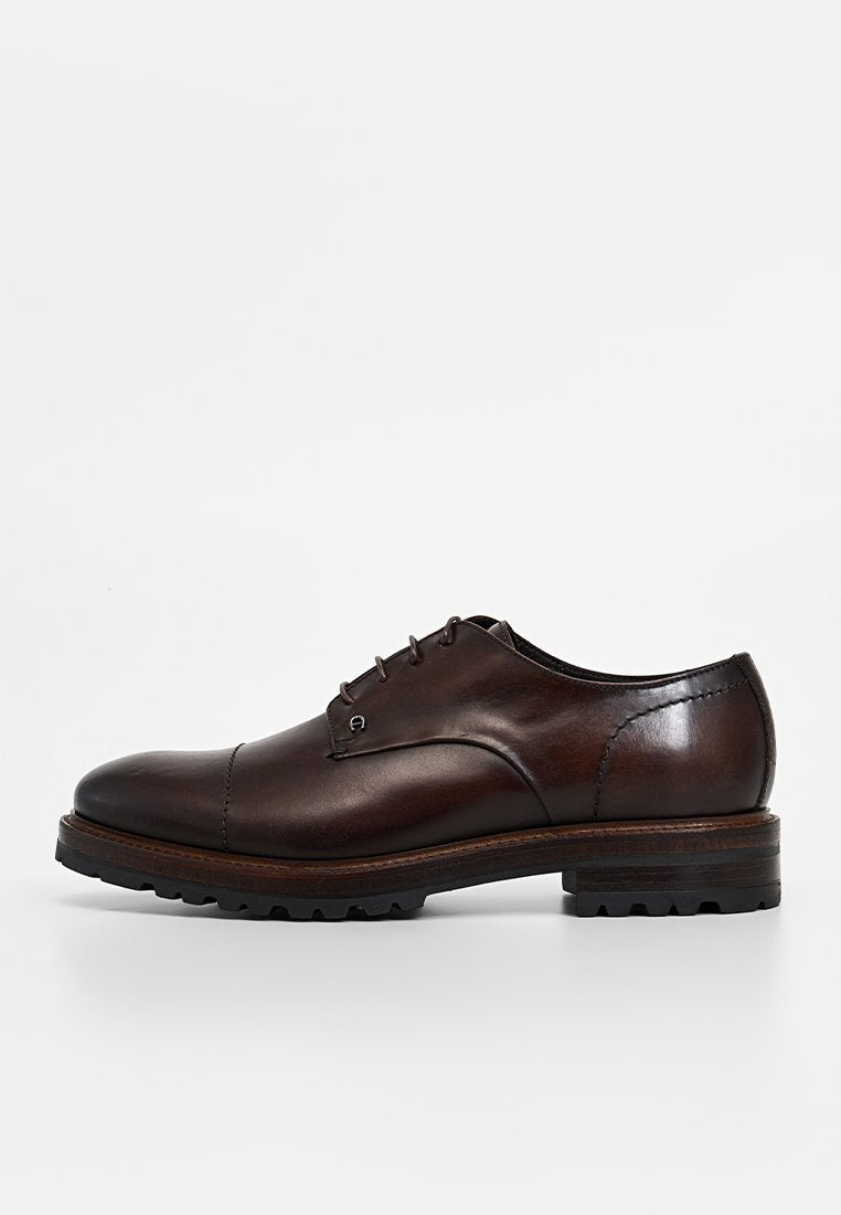 Brauner Lederschuh mit runder Spitze, Schnürverschluss und leichtem Absatz. Verfügt über eine strukturierte Oberfläche und eine robuste Sohle.
