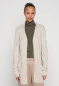 Beiger Strickjacke mit offenem Vorderteil, langen Ärmeln und Seitentaschen. Weicher, strukturierter Strickstoff. Getragen über einem dunkelgrünen Rollkragenpullover.